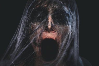 Ürpertici karakter çığlık spiderweb siyah arka plan üzerine kaplı. Halloween korkunç yaratık portre kopya alanı ile