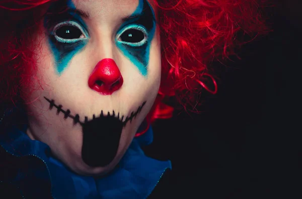 Creepy clown close up spooky halloween portrait on black background