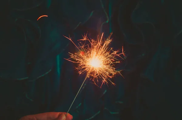 Luz Bengala Uma Mão Com Brilhos Fundo Verde Escuro Azul — Fotografia de Stock