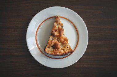 Dilim elma pasta kahverengi ahşap masa üstü görüntüsü üzerinde beyaz plaka üzerinde