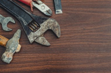 Ahşap zemin ile kopya alanı üzerinde çekiç, somun anahtarı ve pense Üstten Görünüm