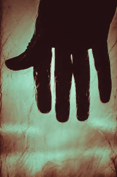 Creepy silhouette of hand on red blurred background — Stock Photo, Image