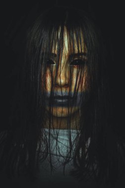 Karanlık arka planda siyah gözlü korkunç cadı