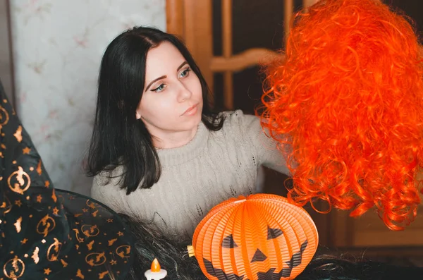 Giovane donna si prepara per Halloween e mantiene una parrucca rossa — Foto Stock