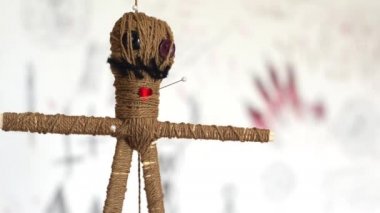 İğneli Voodoo bebek ürpertici semboller ile beyaz arka plan üzerinde yavaş yavaş yuvarlak döner. Kara büyü kavramı