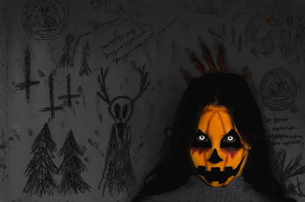 Пухнасте гарбузове обличчя істоти Хеллоуїна на темному тлі з окультними символами — стокове фото