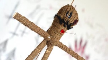 İğneli Voodoo bebek ürpertici ritüel sembolleri ile beyaz arka plan üzerinde yavaş yavaş yuvarlak döner. Kara büyü ve cadılar bayramı konsepti