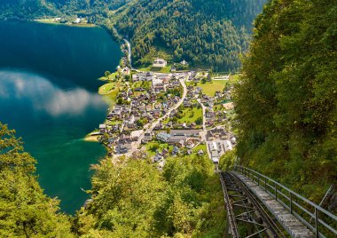 Teleferik, orman ve dağlar Avusturyalı şehir ve mavi gökyüzü bulutlu su yansıması ile Hallstatt jet ile