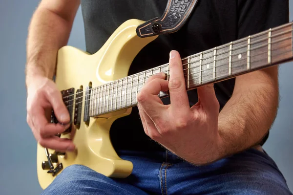 シャツとジーンズ エレキギターを弾きの男 指詳細 青い背景 — ストック写真
