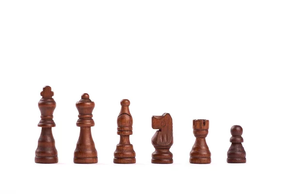 Satz schwarzer Holzschachfiguren, die in einer Reihe auf weißem Hintergrund stehen — Stockfoto