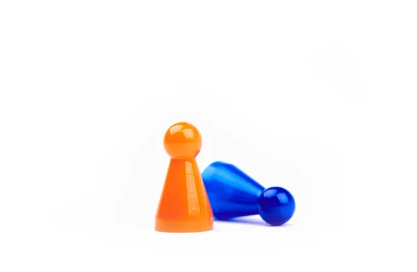 Дві пластикові іграшки Помаранчева фігура, що стоїть як переможець і синя фігура бреше як невдаха ізольовані на білому тлі — стокове фото