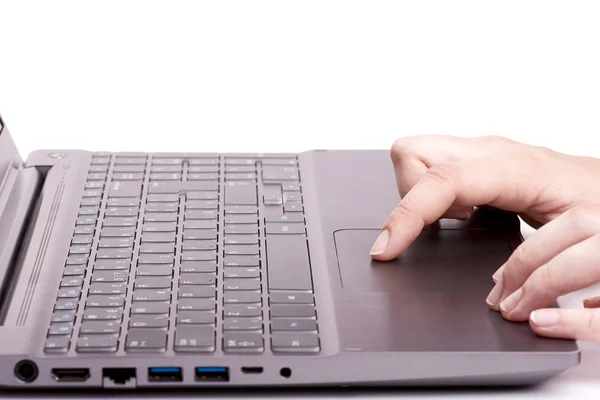 Молодая женщина рука работает на серебряном ноутбуке тачпад — стоковое фото