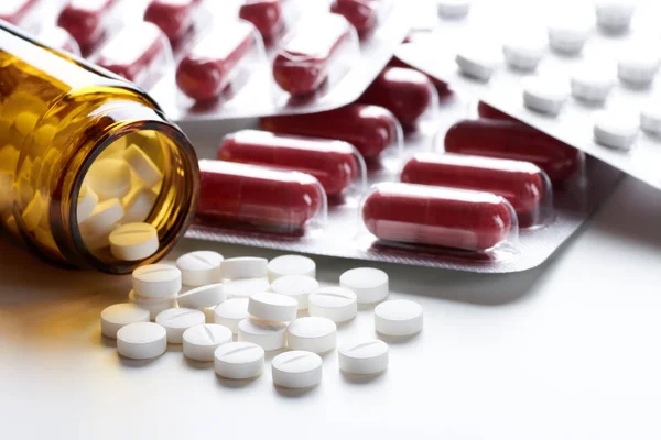 Stos tabletek i tabletek w butelce, szklanym i blistrze opakowaniu na — Zdjęcie stockowe