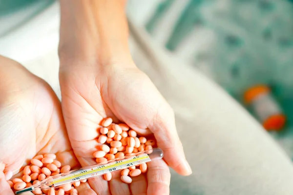 Tabletten Und Thermometer Den Handflächen Großaufnahme Auf Dem Verschwommenen Hintergrund — Stockfoto