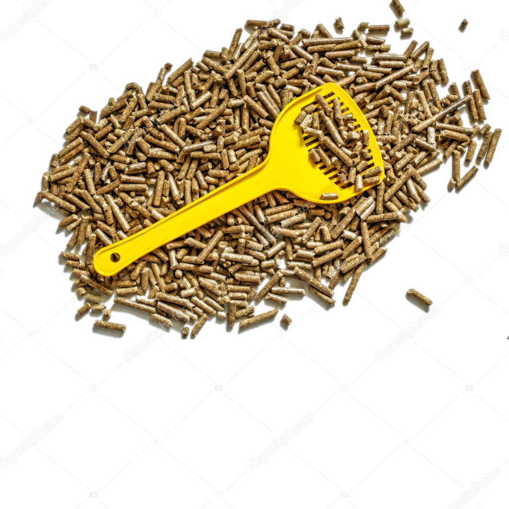Cat litter and yellow showel above, top flat view isolated on the white background with copy-space
