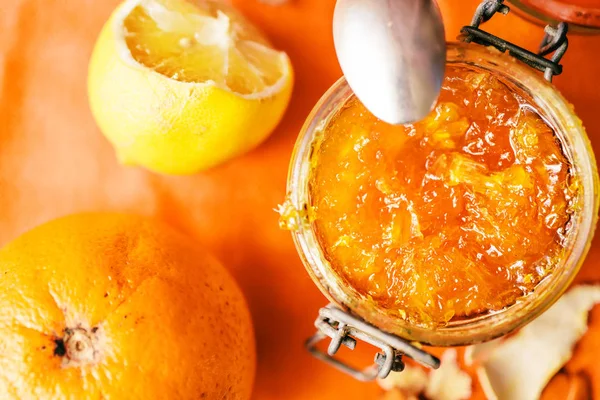 在一个橙色背景的背景上 在一个橙色的玻璃罐子里的橘子果酱 — 图库照片