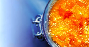 mavi arka plan en iyi düz görünümünde yakın çekim cam kavanozda Portakal Reçeli 