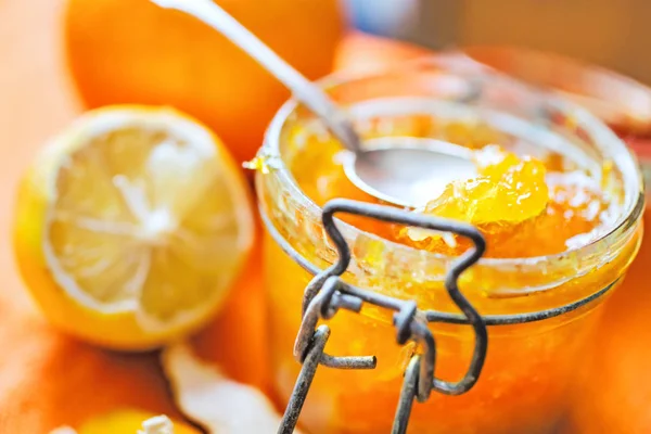 オレンジとレモン オレンジ色の背景のクローズ アップの横にガラスの瓶にオレンジ ジャム ストック画像