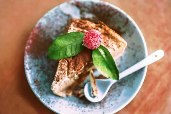 Käsekuchenstück Mit Zimt Und Himbeeren Auf Hellblauem Teller Und Löffel — Stockfoto