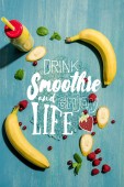 top view of bottle with fresh banana smoothie and berries with mint leaves, with drink smoothieand enjoy life lettering