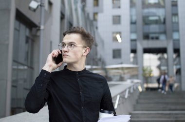 Genç işadamı telefonda konuşuyor.