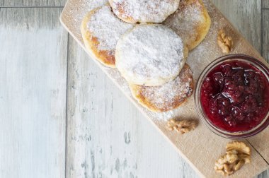 ahududu reçeli ve fındık ile pudra şekeri ile ev yapımı peynir krep ahşap bir tahta üzerinde yalan