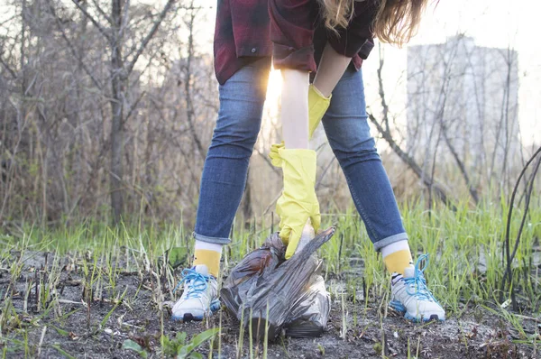 Mädchen säubert den Park, nimmt eine Plastikflasche und wirft sie in den Müllsack — Stockfoto