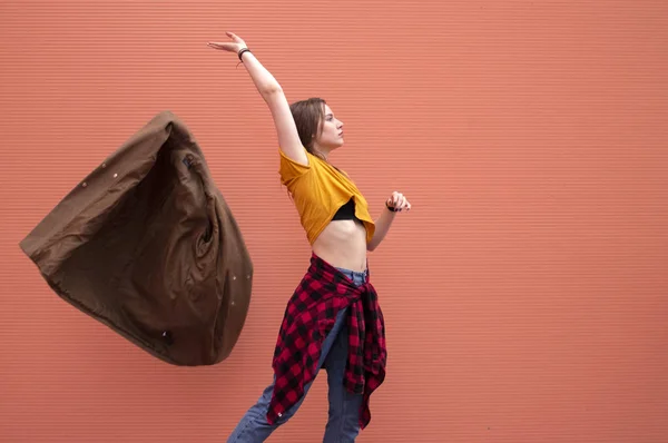 Joven elegante chica lanza hacia fuera en naranja fondo — Foto de Stock