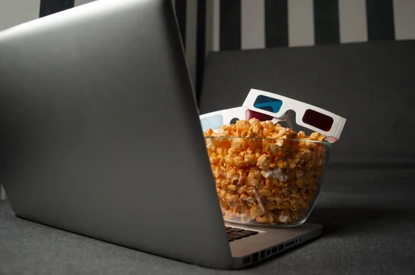 3D glasses, popcorn and a laptop are lying on the sofa in the room at night — Stock Photo, Image