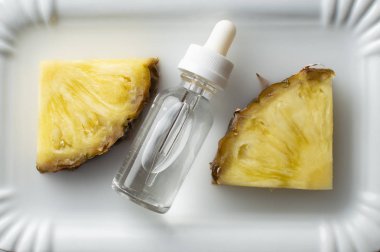 Ananas aromalı vape sıvı ananas iki parça ile beyaz bir tabak üzerinde yatıyor