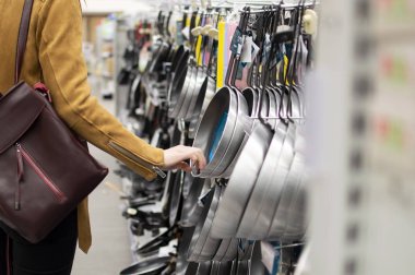 genç bir kız süpermarkete gider, bir ızgara seçer, yemeklerin kalitesini kontrol