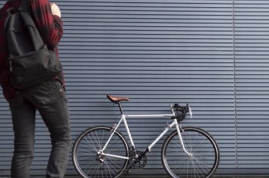 sırt çantası olan genç bir adam beyaz bisiklet gider, öğrenci okula gitmek