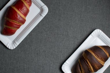 kırmızı ve çikolata kruvasan gri bir arka plan üzerinde plakalar üzerinde yalan