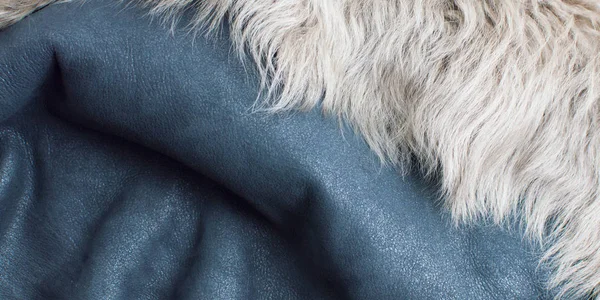 background of blue leather and white fur, folded, textured fabric