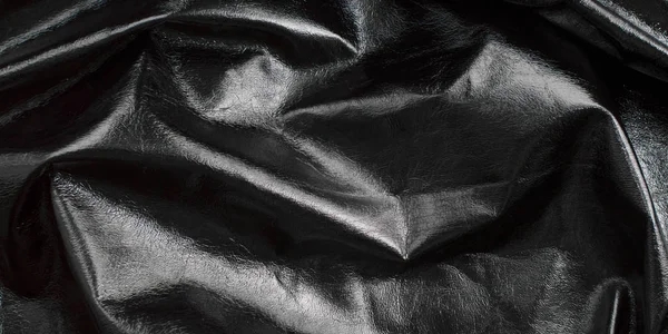 Background of black textured, glossy leather, rumpled, shiny fabric — Stock Photo, Image