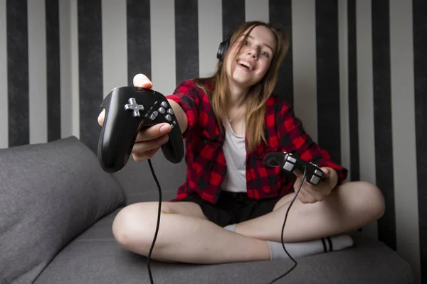 Mooi meisje nodigt je uit om computerspelletjes te spelen 's nachts in de kamer, ze houdt de joysticks en geeft het aan ons, de vrouw wil samen spelen — Stockfoto