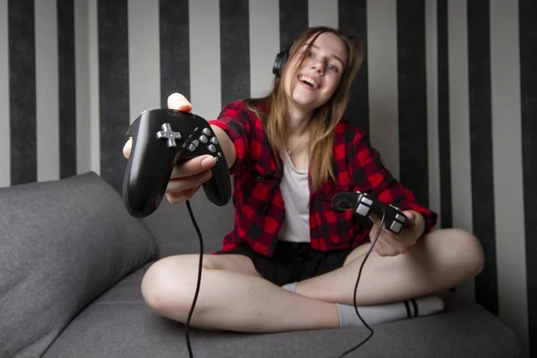 Belle fille vous invite à jouer à des jeux informatiques la nuit dans la salle, elle tient les joysticks et nous les donne, la femme veut jouer ensemble — Photo