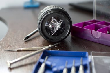 kırık lens araçları ile onarım masasında yatıyor, kırık bir lens yakın çekim, metin için kopya alanı