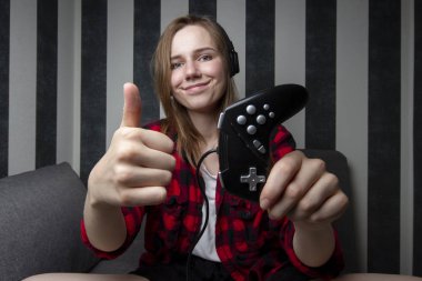 genç kız bir kanepede oturur ve video oyunları oynar, o bir joystick tutar ve gibi gösterir