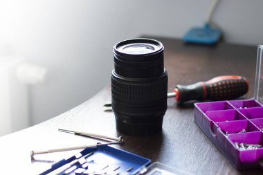 kırık lens araçları ile onarım masasında yatıyor, kırık bir lens yakın çekim, metin için kopya alanı