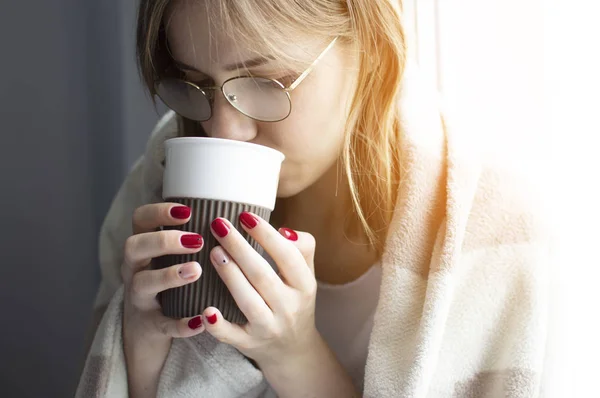 Fiatal lány borított takaró, rendelkezik egy csésze a kezében, és italok tea, ő megbetegszik, és kezelik otthon, közeli — Stock Fotó