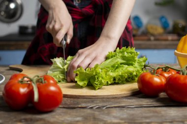 bir masada kız kesilmiş marul ellerini, bir kadın bir vejetaryen salata, sağlıklı gıda, bir bıçak pirzola yeşillik hazırlar