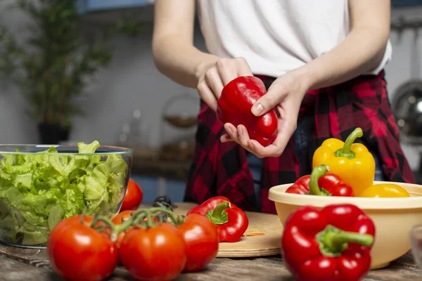 Genç kız mutfakta vejetaryen salata hazırlar, o biber pirzola, sağlıklı gıda hazırlama süreci, yakın çekim