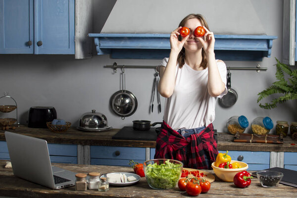 young girl prepares a vegetarian salad in the kitchen, the process of preparing healthy food
