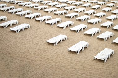 denize yakın birçok boş plaj yatağı, insanlar olmayan bir plaj, terk edilmiş bir dinlenme yeri