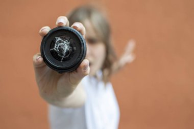 Kız kırık bir fotoğraf objektif tutar, fotoğrafçı cam düştü