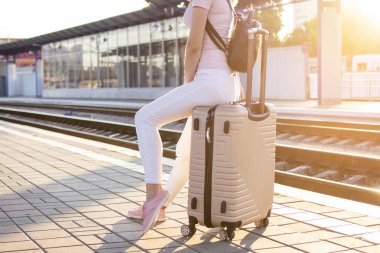 havaalanında bagaj üzerinde oturan ve tren bekleyen çekici kız, öğrenci bir gezi, yakın çekim gider