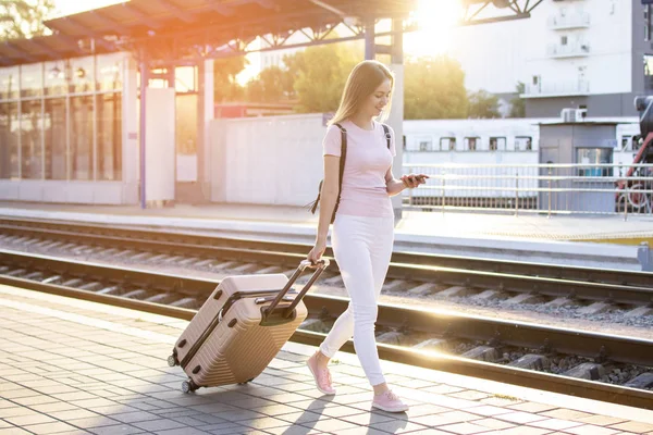 çekici kız istasyonda bagaj ile ayakta ve tren bekliyor, öğrenci bir geziye gidiyor, o platform boyunca yürüyor, kopya alanı