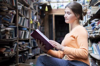 kız öğrenci eski kütüphanede bir kitap okur, bir kadın arşivlerde bilgi arıyor