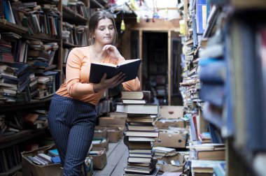 kız öğrenci kütüphanede bir kitap okur, bir kadın çok okumayı seviyor, o kitapraflarında edebiyat arıyor, bilgi güç, kavram